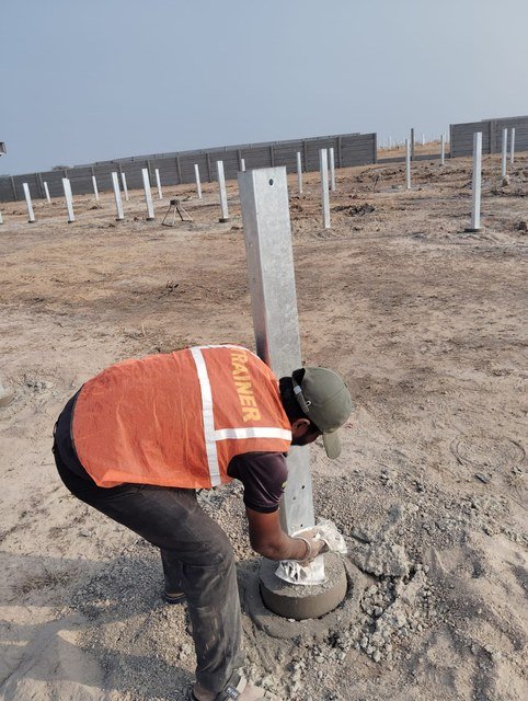 Worker installing solar pole foundation at Tuljapur